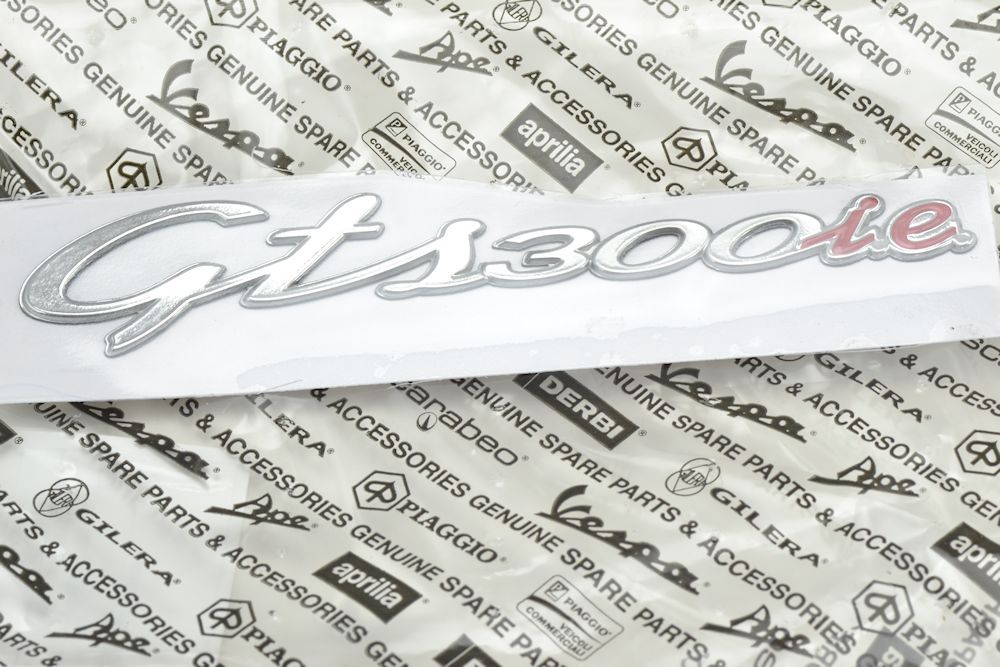 TARGHETTA GTS 300 I.E 145X26 MM CROMATO/ROSSO VESPA GTS 300 I.E ORIGINALE PIAGGIO